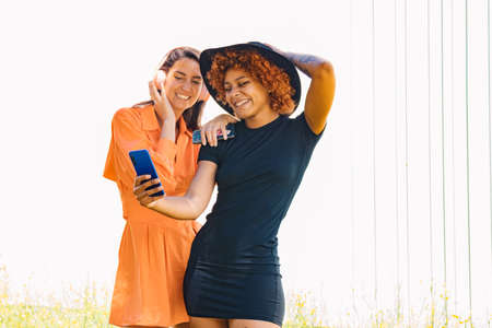 girls with mobile phone and headphones on the street