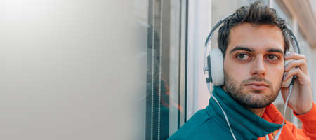 young man with headphones on city street outdoorsの写真素材