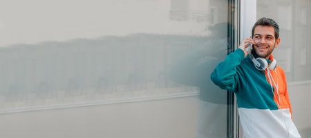 young man with mobile phone on city street outdoorsの写真素材