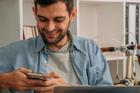 man working at home with computer and using mobile phone