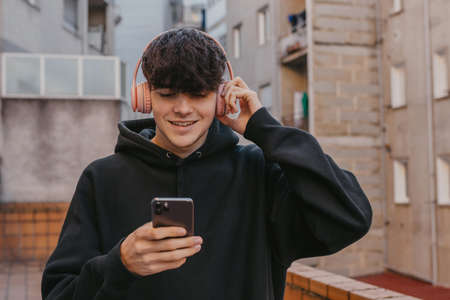 teen boy with headphones and mobile phone on the streetの写真素材