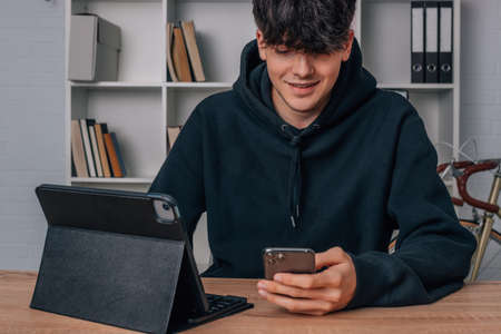 teenager at home with mobile phone and computerの写真素材