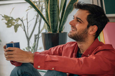 portrait of relaxed man at home with cup of coffeeの写真素材