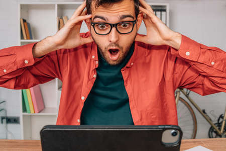 surprised or amazed man looking at the computer