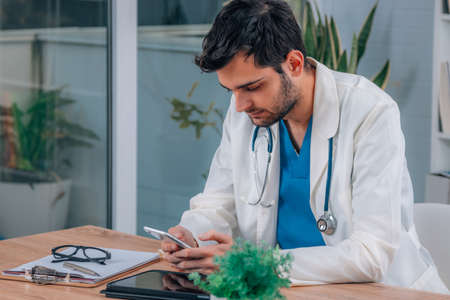doctor with mobile phone in consultation or office