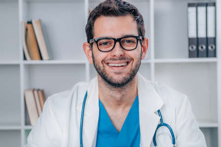 attractive young doctor with uniform and stethoscope workingの写真素材