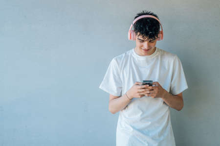 teen boy with mobile phone or smartphone and earphonesの写真素材