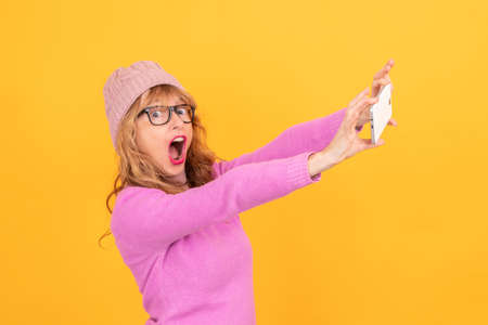 woman isolated on background wearing winter clothes taking photo or recording with mobile phone