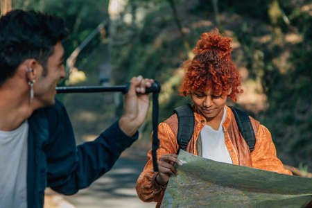young people with map on excursion, trip or hikingの写真素材