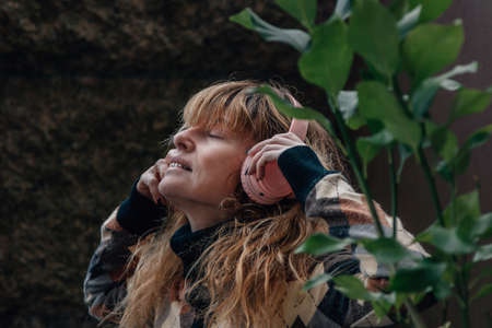 middle-aged woman listening to music with headphones relaxedの写真素材