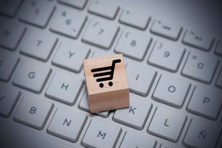 piece of wood with shopping cart on computer keyboard