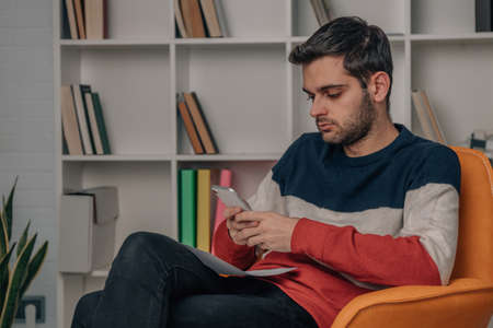 young man at home looking at mobile phone