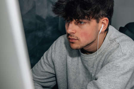 teenager with headphones looking at the computer screenの写真素材