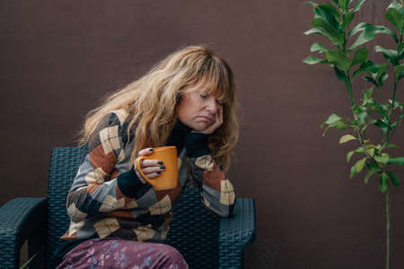 depressed woman alone at home with cup of coffeeの写真素材