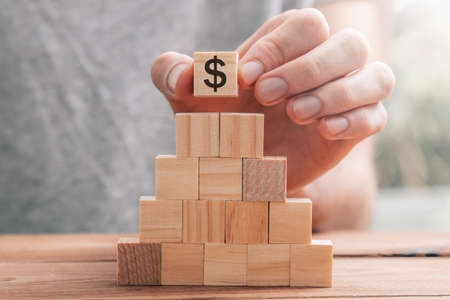 hand with piece with dollar symbol, savings and investment concept