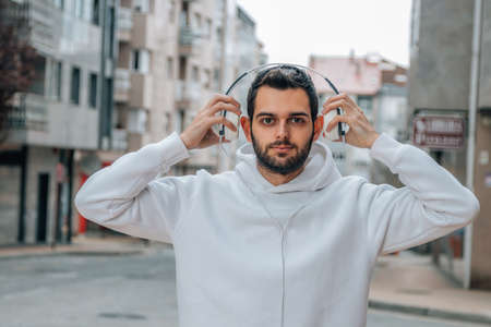 young man with headphones on the street