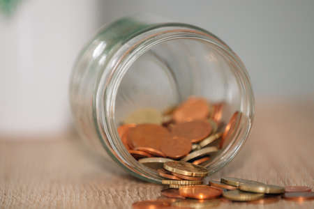 pot with coins poured on the table, savingsの写真素材