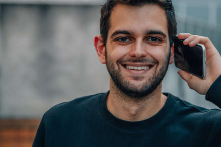 young man talking on mobile or cell phone in the street