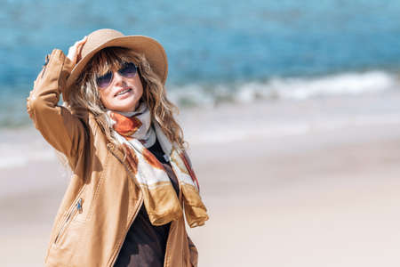 middle aged woman with hat on the beach