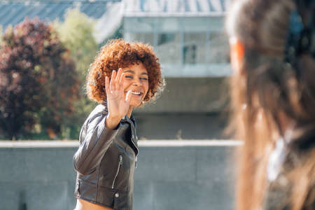 women greeting each other on the street outdoorsの写真素材