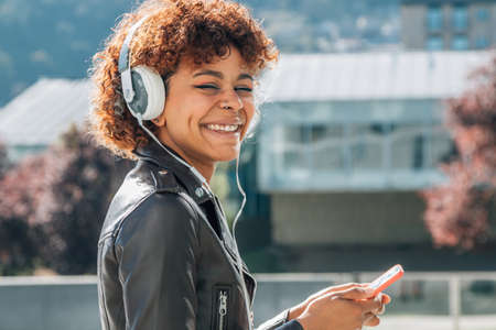 afro american girl with mobile phone and headphonesの写真素材