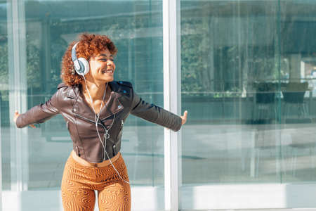 girl with headphones on the street smiling