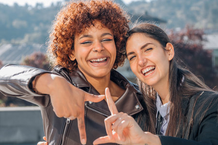two girls friends happy and smiling in the streetの写真素材