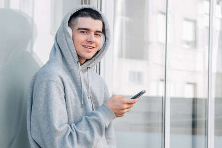 young urban trendy millennial with mobile phone and earphones