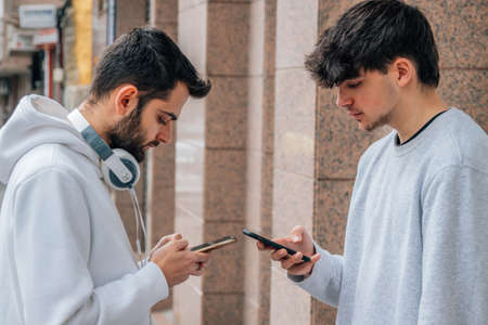 young people with mobile phone in the streetの写真素材