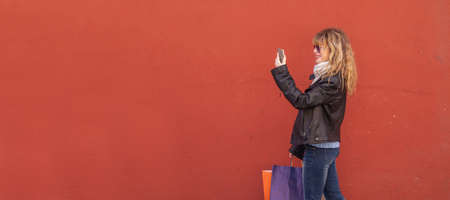 woman with shopping bags isolated on the wall in the street outdoorsの写真素材