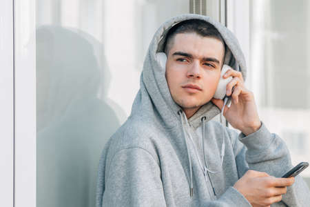 young teenager boy with mobile phone at home sitting comfortably on the floor
