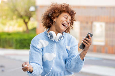 african american girl on the street with mobile phone