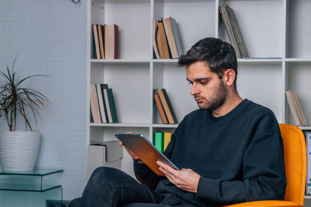 young man with digital tablet or laptop at home excited celebrating successの写真素材