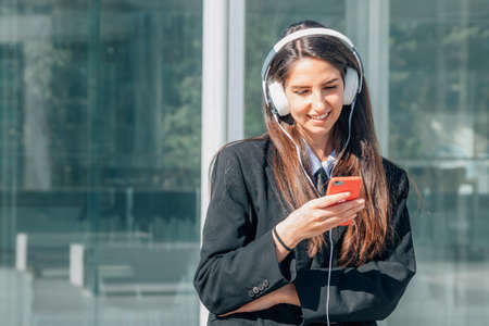 girl with mobile phone and headphones on the street