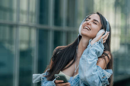 girl with headphones and mobile phone listening to music outdoorsの写真素材