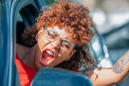 girl driving protesting aggressive out the windowの写真素材