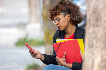 afro american student with books and mobile phoneの写真素材