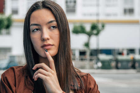 girl with thoughtful expression or doubt outdoors