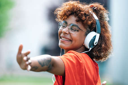 african american girl with headphones dancing happyの写真素材
