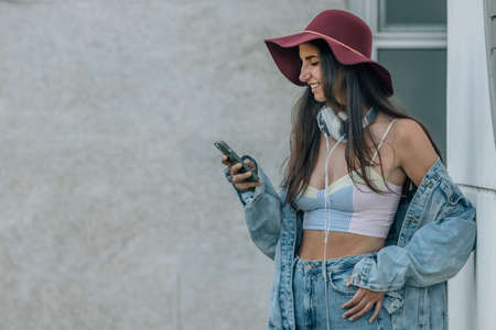 urban trendy hipster girl with mobile phoneの写真素材