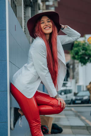 redhead hipster with hat on the street wall