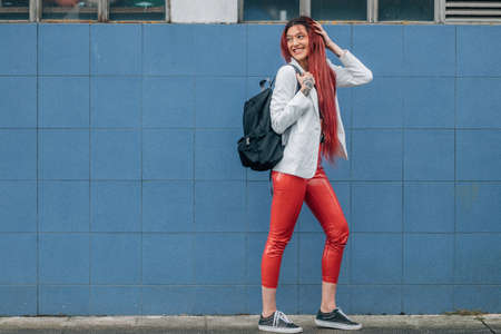 red-haired girl walking happily on the streetの写真素材