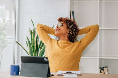 african american woman with laptop relaxing at home
