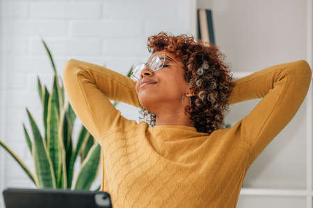 african american woman with laptop relaxing at home