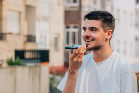 young man with mobile phone sending voice message