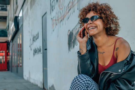 black african american girl talking on mobile phone or smartphone in the street outdoorsの写真素材