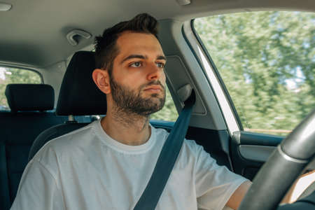 young man behind the wheel of the car drivingの写真素材
