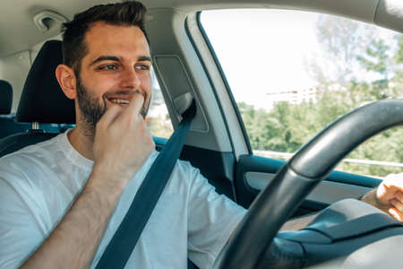 young man behind the wheel of the car driving