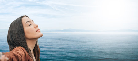 girl breathing relaxed outdoors with sea backgroundの写真素材