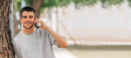 young man talking on mobile phone or smartphone in the streetの写真素材